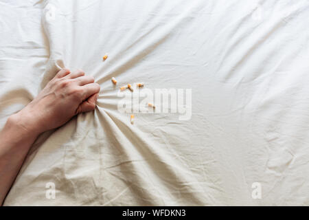 Blick von oben auf die Frau hand Selbstmord durch Überdosierung von Medikamenten. Nahaufnahme einer Überdosis Pillen und Süchtigen. Überdosierung Konzept. Stockfoto