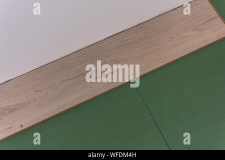 Installation Laminat im Zimmer, Bettwäsche umweltfreundlich Fußbodenheizung und Laminat oder Parkett Stockfoto