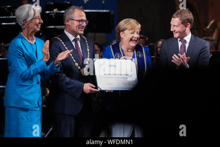 31. August 2019, Sachsen, Leipzig: Christine Lagarde, designierter Präsident der Europäischen Zentralbank (EZB), Stephan Stubner, Rektor der Leipzig Graduate School of Management (HHL), Angela Merkel (CDU), Bundeskanzler der Bundesrepublik Deutschland, und Michael Kretschmer (CDU), Ministerpräsident von Sachsen, wird auf der Bühne während der abschlussfeier werden Nachdem der Kanzler mit der Ehrendoktorwürde ausgezeichnet wurde. Merkel die Ehrendoktorwürde von der HHL für ihre politischen Führungsstil. Für die Bundeskanzlerin ist es schon der 17. Verleihung der Ehrendoktorwürde. Foto: Jan Woitas/dpa-Zentral Stockfoto