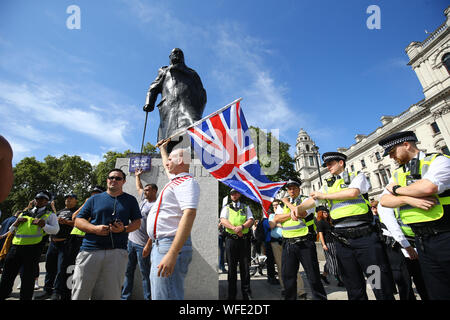 Pro-Brexit Demonstranten im Churchill Statue in Westminster Square in London, als anti-Brexit Demonstranten an der 'Lasst uns 'Tag der Aktion, organisiert durch Ein anderes Europa ist möglich Kampagne Gruppe in London gegen Premierminister Boris Johnson die Entscheidung des Parlaments für bis zu fünf Wochen auszusetzen, vor der Queen's Speech am 14. Oktober unter Beweis zu stellen. Stockfoto