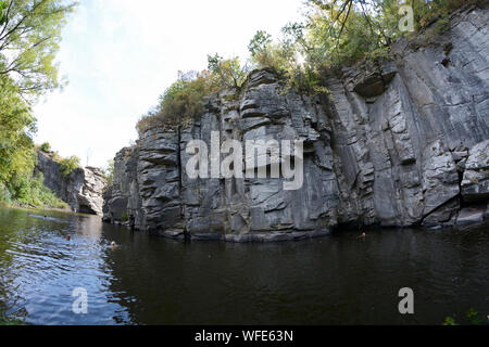 Menschen schwimmen im Fluss vor Felsen der Buksky Canyon. August 27, 2019. Cherkasskaya oblast, Ukraine Stockfoto