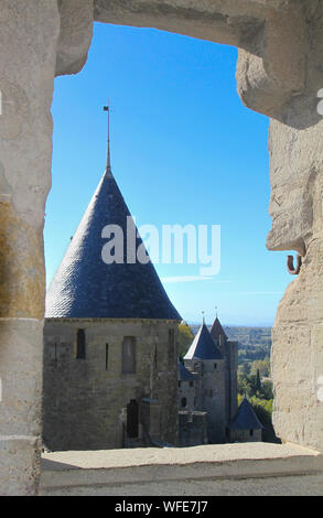 Blick durch die Öffnung in der Mauer Mauer mit Wachtürmen und blauer Himmel. Carcassonne die mittelalterliche Stadt. Frankreich, Europa an einem sonnigen Tag Stockfoto