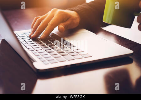 Business Mann mit Laptop Computer. Männliche hand Tippen auf Laptop Tastatur Stockfoto