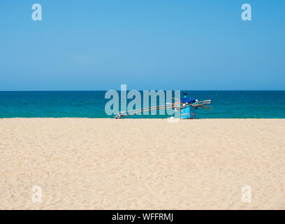 Traditionelle hölzerne Fischerboot auf leeren Strand gegen den klaren, blauen Himmel und Meer, Strand, Kallady Batticaloa, Sri Lanka. Stockfoto