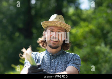 Porträt eines Mannes stehen im Garten eine Pflanze, Deutschland Stockfoto