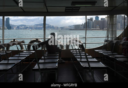 (190831) - HONGKONG, Aug 31, 2019 (Xinhua) - ein Passagier der Star Ferry von Hong Kong Island, in Tsim Sha Tsui, Hong Kong, South China, August 18, 2019. Hong Kong Günstige internationale Bild- und die geschäftliche Umgebung hat getrübt worden als gewalttätig und zerstörerisch Proteste bereits seit mehr als zwei Monaten. Direkten und negativen Auswirkungen der Störung auf die Wirtschaft sind im Einzelhandel, Gastronomie und Tourismus, die zu Entlassungen inmitten der starke Rückgänge bei Umsatz, die Zahl der Kunden und Einnahmen zu Resort sichtbar. Im Juni-Juli, durchschnittliche Einkommen für zu Stockfoto