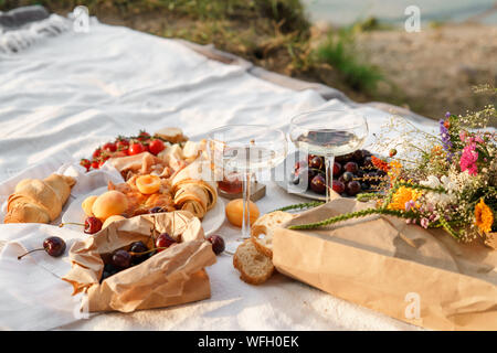 Das Essen bei einem Picknick und Gläser Wein auf einer Decke Stockfoto