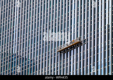 Mann Reinigung Fenster eines Hochhauses, Indonesien Stockfoto