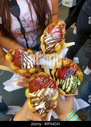 Gesellschaft von Freunden in einem Kreis mit 4 Kegel von Waffeln Bubble Ice Cream in Großbritannien angeordnet Stockfoto
