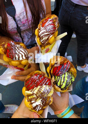 Gesellschaft von Freunden in einem Kreis mit 4 Kegel von Waffeln Bubble Ice Cream in Großbritannien angeordnet Stockfoto
