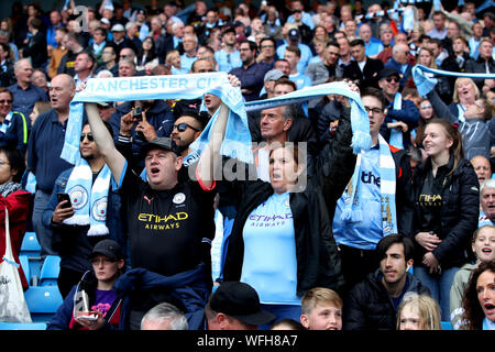 Manchester City Fans auf den Tribünen zeigen ihre Unterstützung während der Premier League Match an der Etihad Stadium, Manchester. Stockfoto