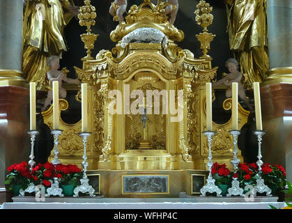 Mittenwald, Deutschland, 10. August, 2019: Halter Kerze mit Kerzen, Rosen und Schmuck vor der vergoldete und versilberte Altar der Katholischen Kirche Stockfoto