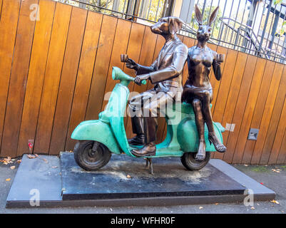 Bronze Skulptur von dogman und Rabbitwoman auf einer Vespa von Bildhauern Gillie und Marc Schattner in Surrey Hills Sydney, NSW, Australien. Stockfoto