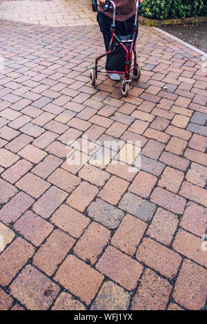 Ältere Person mit einem 3-Rad Rollator Gehhilfe Stockfoto
