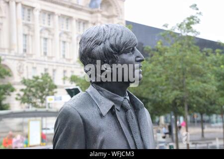 Skulptur der Beatles auf Pier Head, Liverpool, England, bei Regenwetter. Detail: Portrait von John Lennon. Artist: Andy Edwards. Europa. Stockfoto