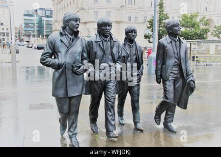 Skulptur der Beatles auf Pier Head, Merseyside, Liverpool, bei Regenwetter. Im Jahr 2015 installiert. Artist: Andy Edwards. Europa. Stockfoto