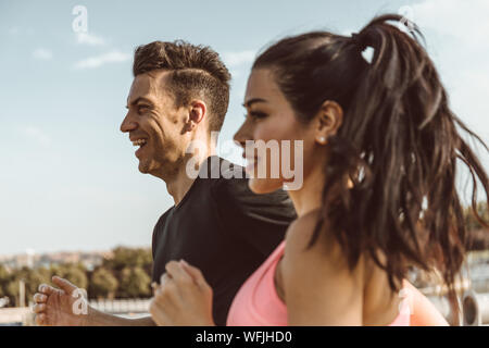 Kaukasische Mann geht heraus laufen zu lassen und Sport mit lateinischen Frau durch einen Park in der Stadt Madrid. Stockfoto