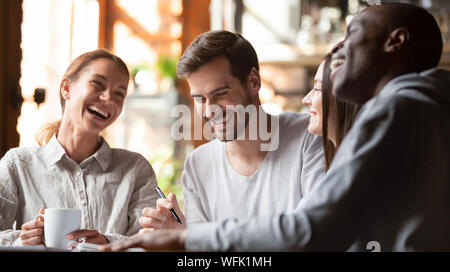 Happy multirassischen junge Freunde gemeinsam entspannen reden lachen im Cafe Stockfoto