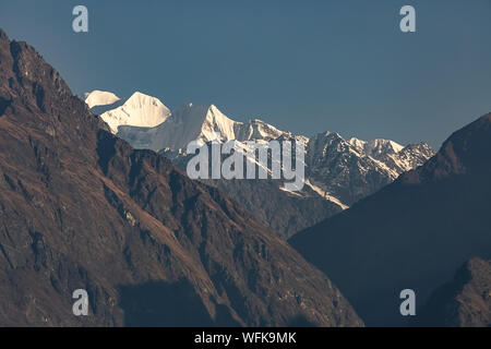 Mount Trishul Himalayan snow Peaks mit karge Gebirgszüge im Sunrise ab Kausani Uttarakhand Indien gesehen. Stockfoto