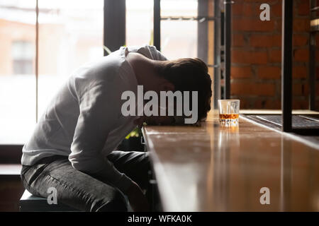 Jung getrunken süchtig Mann Trinker allein Schlafen in bar betätigt Stockfoto