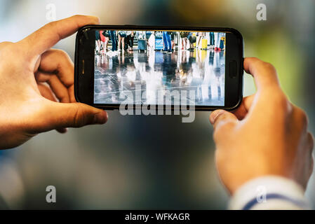 Nahaufnahme der Mann oder die Frau ein Bild von den Beinen von einer großen Gruppe von Menschen, die darauf warten auf Ihren Flug am Flughafen ein - Warten am Th eingeben Stockfoto