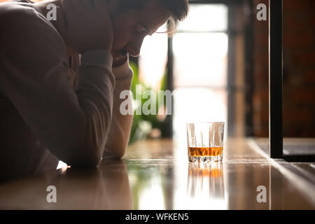 Traurig betrunken süchtig Mann trinken Whisky allein in bar betätigt Stockfoto