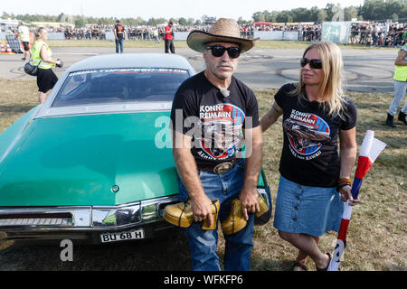 Hasenmoor, Deutschland. 31 Aug, 2019. TV Auswanderer Konny Reimann präsentiert seine Buick-Riviera mit Frau Manuela vor dem wichtigsten Rennen in der "Werner"-Festival. Quelle: Markus Scholz/dpa/Alamy leben Nachrichten Stockfoto