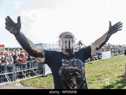 Hasenmoor, Deutschland. 31 Aug, 2019. Die TV Auswanderer Konny Reimann, der in der "Werner" die wichtigsten Rennen verloren, wirft seine Arme zum Beifall nach dem traditionellen Schlammbad. Quelle: Markus Scholz/dpa/Alamy leben Nachrichten Stockfoto