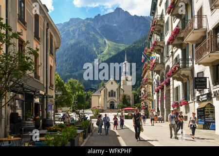 Street View mit Touristen, die Kirche von Saint-Michel und Le Brévent Berg im Hintergrund im Sommer, Chamonix-Mont-Blanc, Alpen, Frankreich Stockfoto