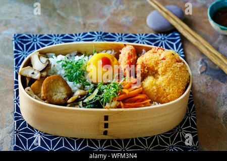 Japanische Bento Box mit Tempura Garnelen, Reis und Gemüse Stockfoto