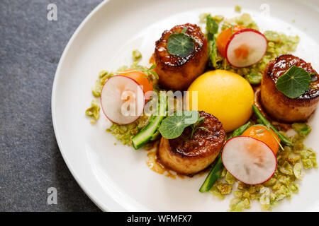 König Oyster mushroom Jakobsmuscheln, Confit Eigelb und Wasabi Erbsen Krümel Stockfoto