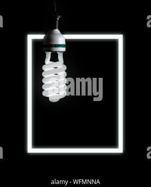 Die weiße Lampe liegt auf schwarzen Hintergrund mit neon Rahmen. Stockfoto