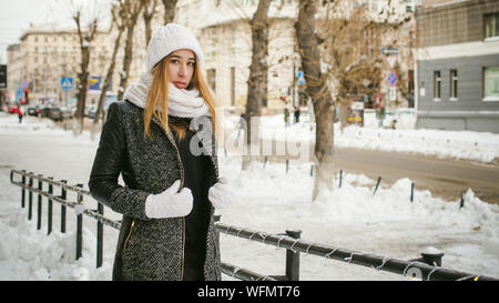 Porträt der jungen Frau trägt warme Kleidung in der Stadt im Winter