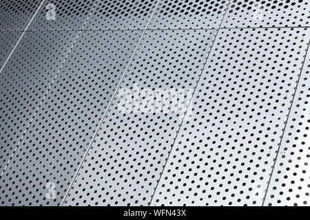 Blick diagonal von metall gitter und runde Löcher in metallenen Oberfläche, gelochte Paneele Stockfoto