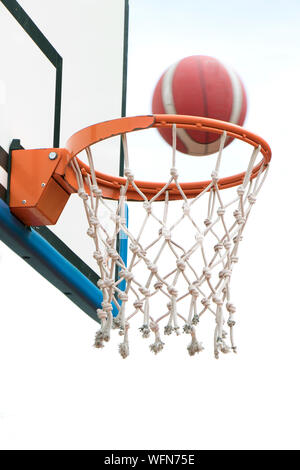 Basketball Sieg, eine Kugel durch Warenkorb Ring und net in motion blur gehen. Eine erfolgreiche klare Punkt in niedrigen Winkel, Detail Stockfoto