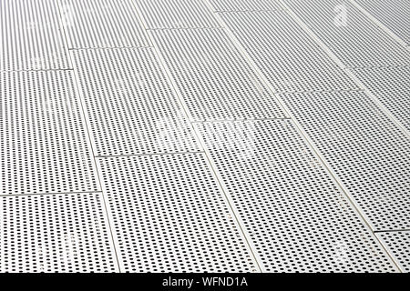 Blick diagonal von metall gitter und runde Löcher in metallenen Oberfläche, gelochte Paneele Stockfoto