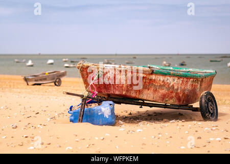 Alte und rostige Boot am Strand und im Meer eine Gruppe von Boote segeln Stockfoto