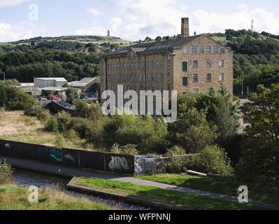 Rückseite der Torheit Halle Mühle mit Blick über die Huddersfield schmalen Kanal und Fluss ex Joseph Lumb jetzt durch das NHS verwendet Stockfoto