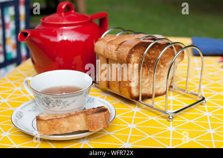 Einen Snack oder Kaffee Zeit außerhalb mit einer Teekanne, Tasse Untertasse und Toast. Stockfoto