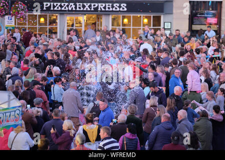 Devizes, Wiltshire, UK. 31. August 2019. Die Schlacht ist eine lustige halbe Stunde im Marktplatz von Devizes, wo Freunde, Familie und völlig fremden Konfetti über einander werfen, wie von den Bären Hotel gesehen. Bisherige Veranstaltungen angezogen haben über 3000 Menschen und dieses Jahr ist es nicht anders. Konfetti ist von den Organisatoren und eine der Taschen hat eine goldene Karte, die den Sieger zu einem geheimen Preis zur Verfügung. Credit: Herr Standfast/Alamy leben Nachrichten Stockfoto