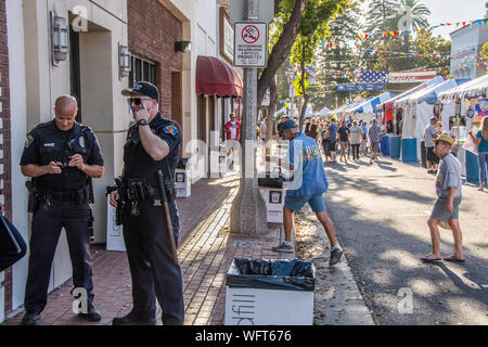 Zwei Polizisten patrouillieren die Website der Orange International Street Fair. Stockfoto