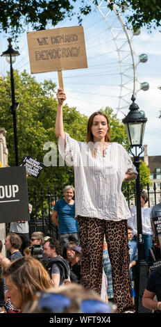 31.Aug 2019 - London, UK. Eine Anti-Brexit Demonstrant hält Banner "Wir fordern Demokratie" außerhalb der Downing Street Gates in Whitehall. Stockfoto