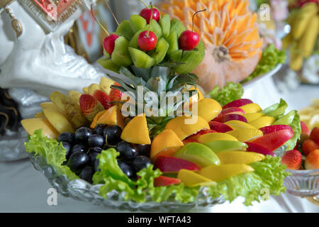 Gehackte Früchte im Glas. Teller geschnitten saisonale Früchte wie Kiwi, Ananas, Rippe, Zitrone, Apfel bereit zu essen. Gesunde Ernährung und Lebensstil. Frische Stockfoto