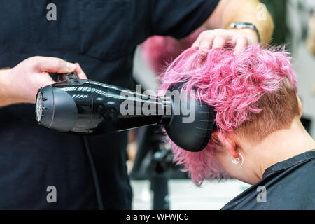 Professionelle Friseur trocknet das Haar mit einem Haartrockner in der Schönheit Friseur Stockfoto