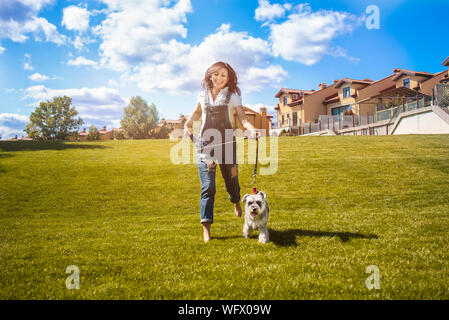 Nach Kaukasischen glückliche Frau im Park laufen mit ihrem geliebten Hund Schnauzer. Spaß Stimmung Stockfoto