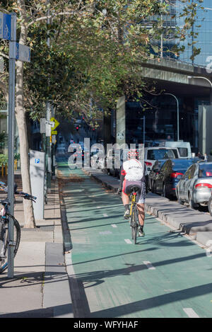 Eine erwachsene männliche Radfahrer Fahrten in einem eigenen geschützten Fahrrad Lane an der Kent Street in Sydney, Australien Stockfoto