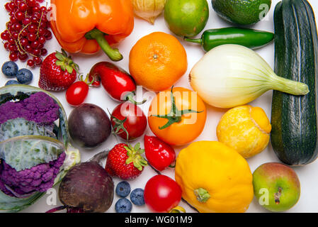 Sortiert von frischem Obst und Gemüse in einem Regenbogen Farbe Muster über whiate Hintergrund angeordnet Stockfoto
