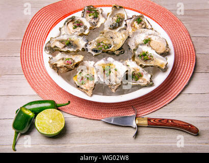 Detail einer Platte mit frischen Spezialitäten Austern mit Jalapeno & Zitrone mignonette über Holz Hintergrund Stockfoto