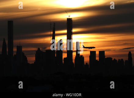 New York, USA. 31 Aug, 2019. Ein Flugzeug fliegt durch die Skyline von Manhattan bei Sonnenuntergang von Arthur Ashe Stadium an der 2019 US Open Tennis Championships am USTA Billie Jean King National Tennis Center am Samstag, 31. August 2019 in New York City. Quelle: UPI/Alamy leben Nachrichten Stockfoto