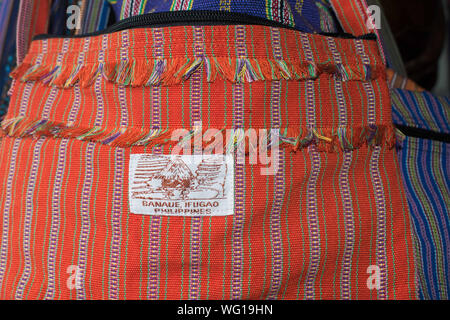AUGUST 25, 2019 - BANAUE IFUGAO PHILIPPINEN: Banaue Produkte auf einen Souvenir Shop in Banaue verkauft. Gewebe Geldbeutel vom Gewinde, Rot in der Farbe. Stockfoto